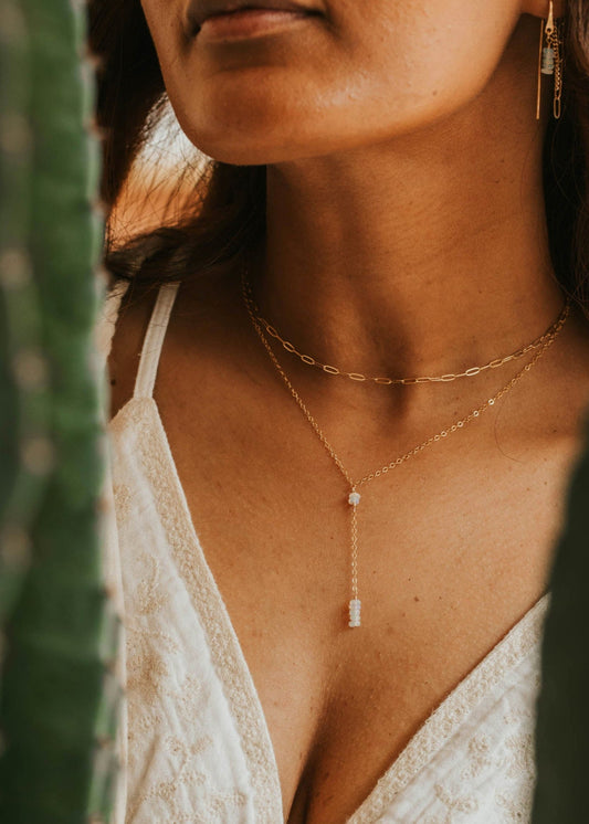 Woman wearing a white lace dress with a blurred natural background
