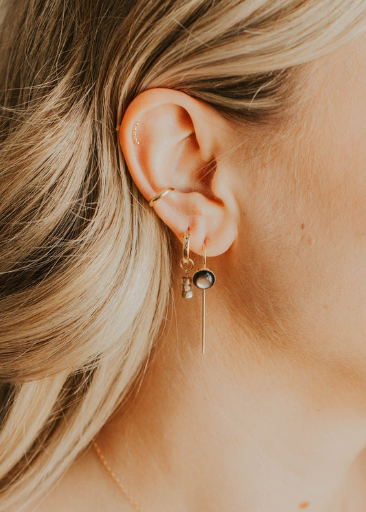 Close-up of a person wearing an earring with a blurred background