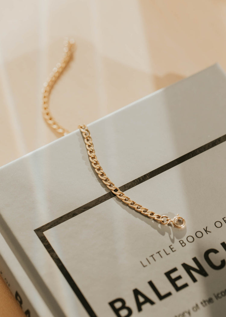 Gold bracelet on a Balenciaga book