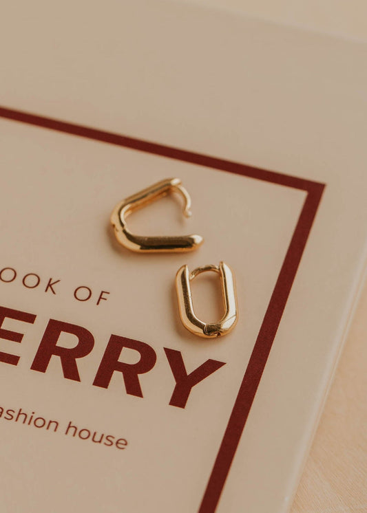 Gold hoop earrings on a beige background