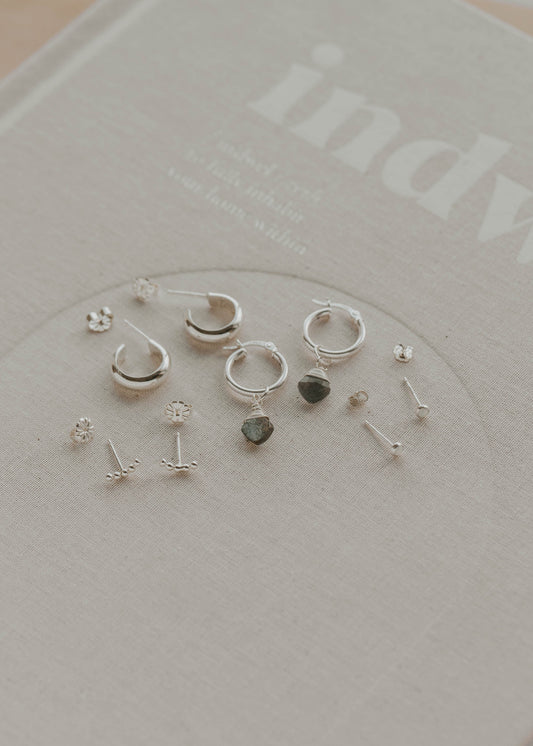 Collection of silver earrings on a branded card