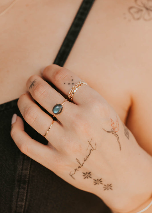 Hand with tattoos and rings on a blurred background