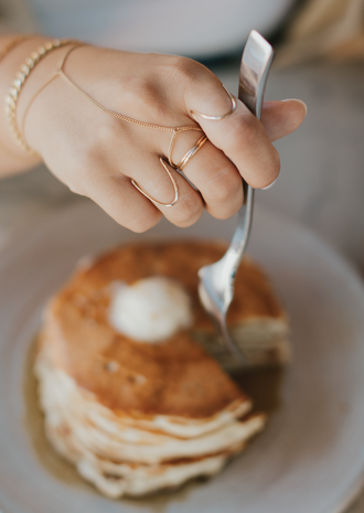 Gold ring stack featuring statements rings, simple stacking rings, and a chain ring by Hello Adorn. 