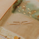 Gold earrings on a textured ceramic surface