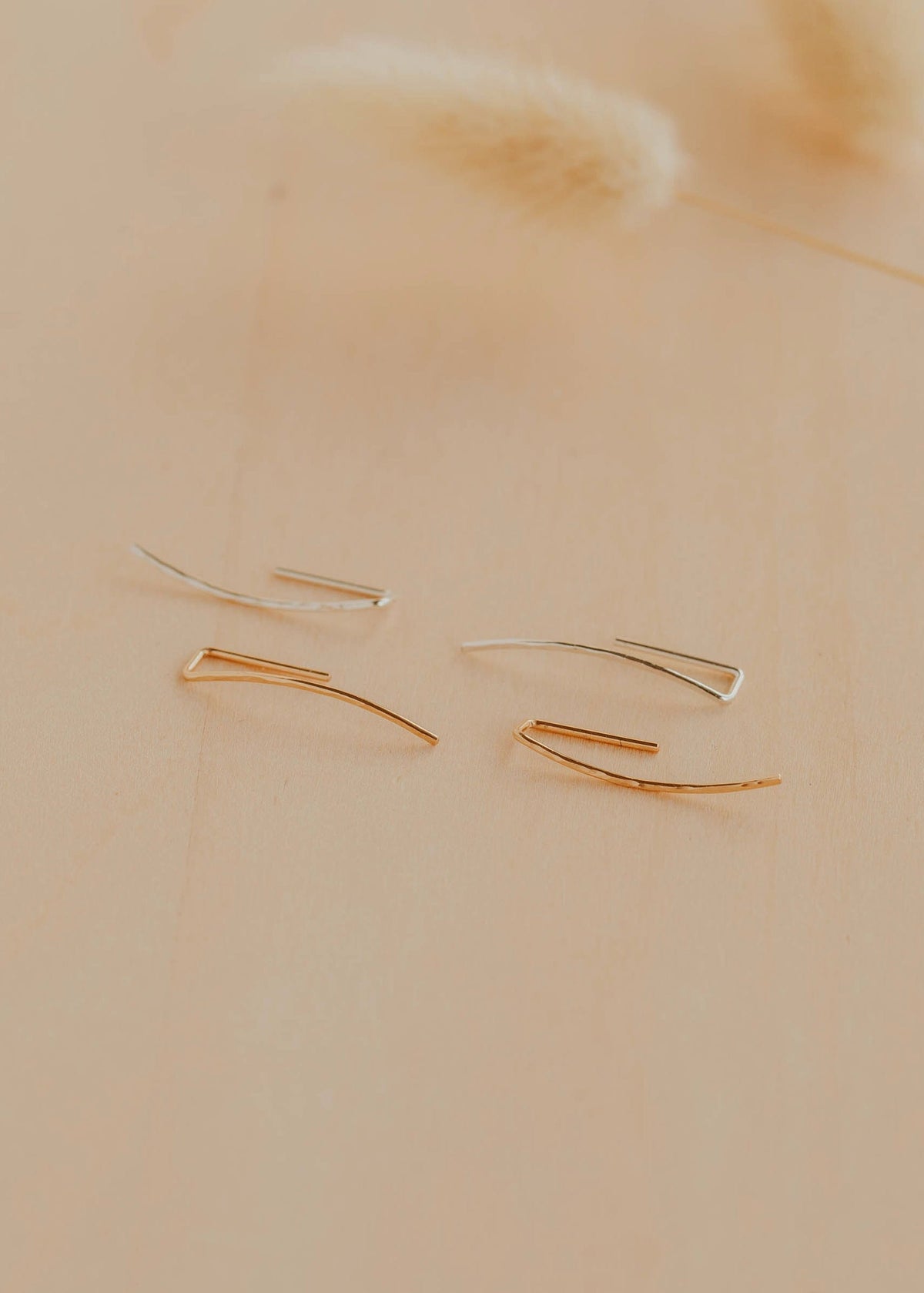 Gold earrings on a beige background