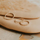 Three gold stacking rings in confetti band style laying flat on a jewelry tray by Hello Adorn.