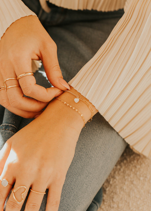 Close-up of hands with jewelry on a neutral background