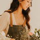 Woman arranging flowers in a vase with a neutral background