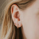 Beaded hoop earrings styled with a double up post to create a fake double piercing creating an earring stack shown in 14k gold fill.