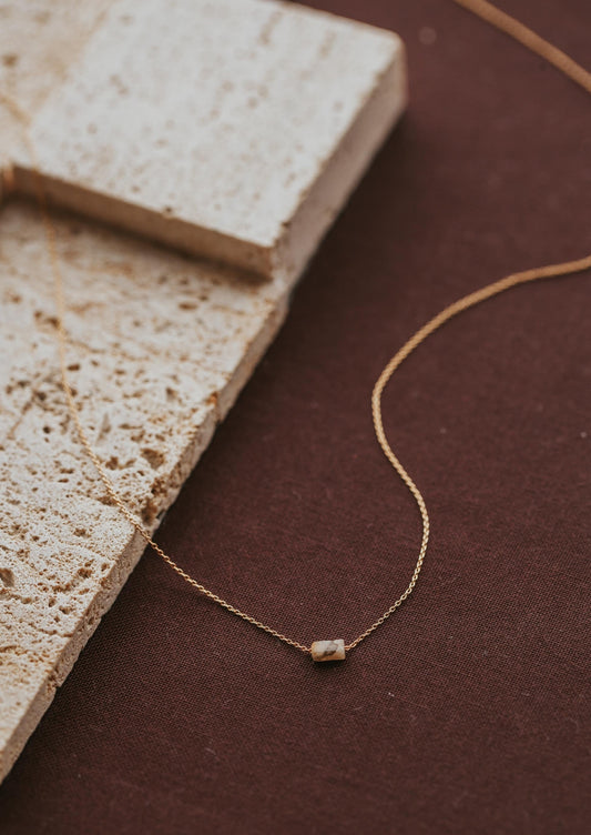A close up look at the Tiny Gemma Necklace from Hello Adorn, a gold stone necklace part of the gemstone jewelry collection.