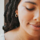 Medium gold hoop earring in 14k gold fill styled with a circle necklace by Hello Adorn.