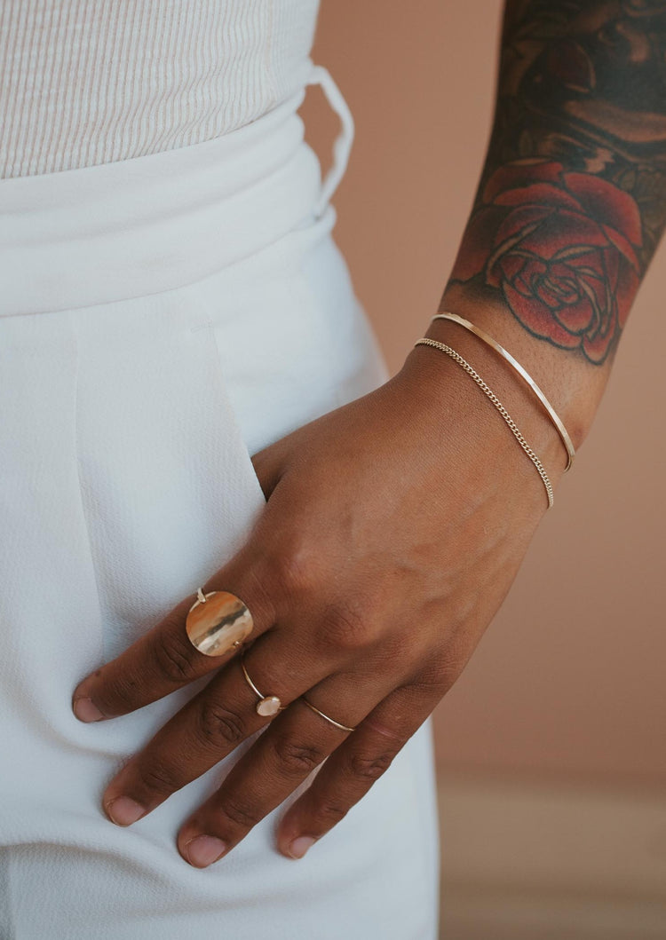 A jewelry idea featuring a Tides Cuff created from a simple cuff bracelet with a chain bracelet attached and styled and styled with a ring stack featuring a statement ring in Supermoon Ring, a gemstone ring, and a thin ring from Hello Adorn.