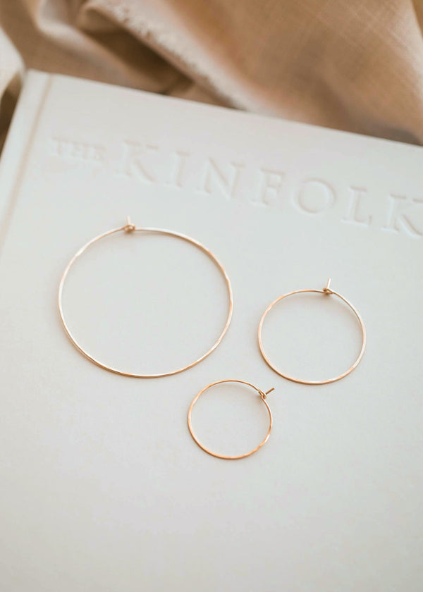 Thin hoop earrings in Cypress Hoops design created by Hello Adorn in three different sizes of hoops, a small hoop earring, medium hoop earring, and large hoop earring for everyday jewelry.