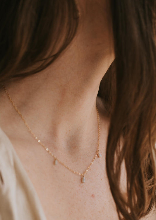 A young model wearing a delicate 14kt Gold Fill gemstone drop necklace with three amazonite drops.