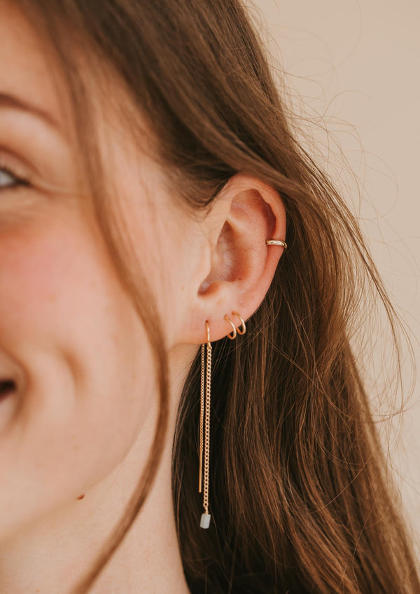 A young model wears a 12 gauge gold fill ear cuff in her cartilage. 