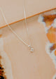 Sterling Silver Grace Necklace by Hello Adorn - tiny CZ pendant on silver chain against ceramic dish