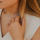 Close-up of a woman wearing a necklace and bracelet with a blurred background