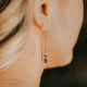 Close-up of a woman wearing a gold earring with a blurred background
