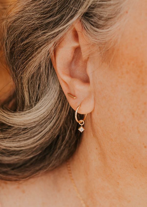 14K Gold Fill Grace Charms by Hello Adorn - CZ star charm huggie worn in model's ear close-up