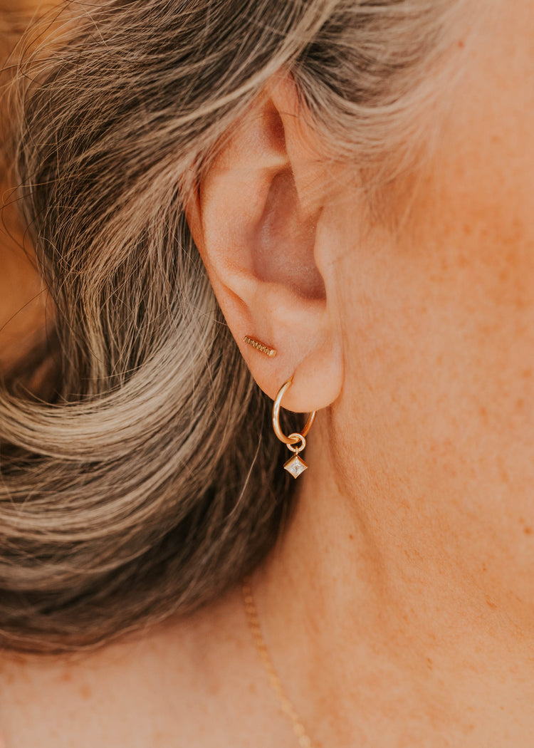 14K Gold Fill Grace Charms by Hello Adorn - CZ star charm huggie worn in model's ear close-up