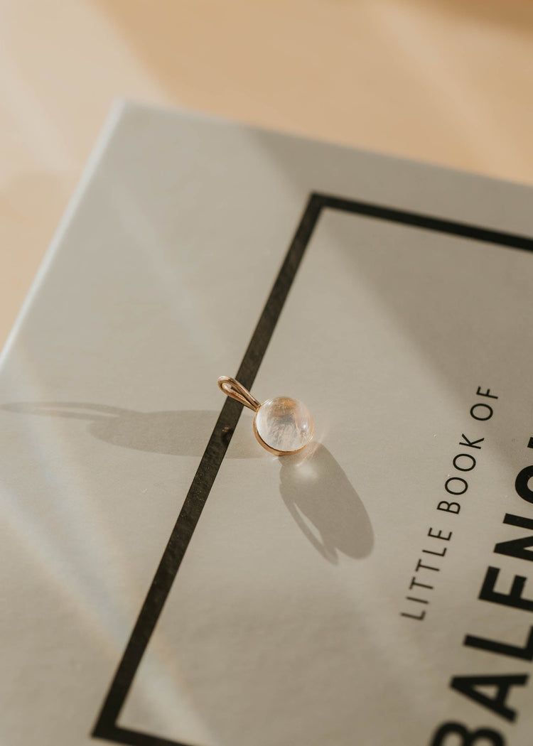 Gold pendant on a Balenciaga book