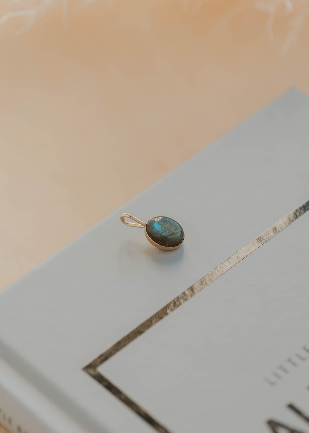 Gold pendant with a labradorite gemstone on a book
