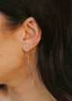 Close-up of a person wearing gold earrings with dark hair.