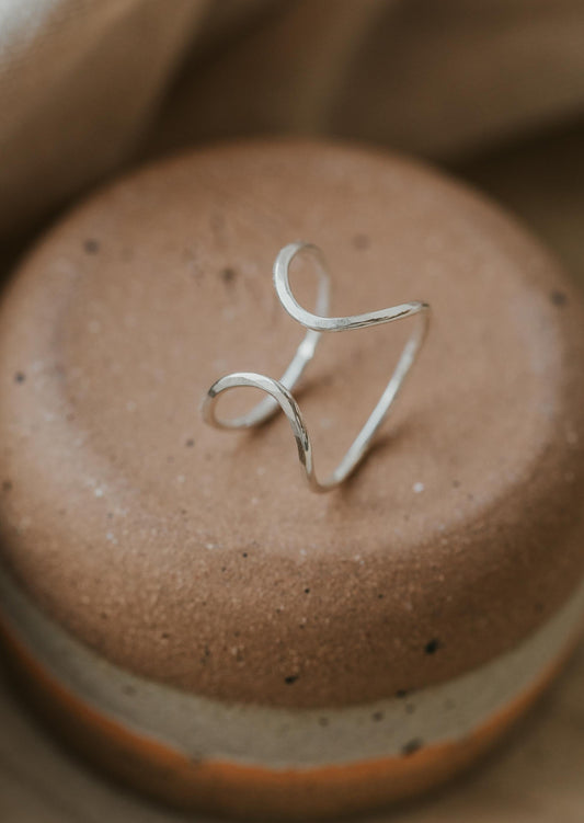 A silver open ring created by Hello Adorn, a piece of wire ring jewelry turned into a statement ring for your ring stack.