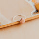 Sterling Silver Rosalie Ring by Hello Adorn - oval pink stone in silver bezel resting on wood surface