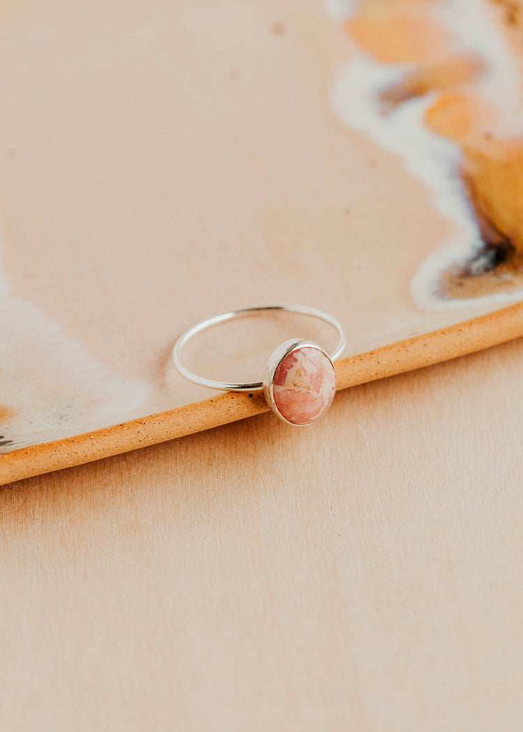 Sterling Silver Rosalie Ring by Hello Adorn - oval pink stone in silver bezel resting on wood surface