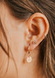 hoop charm on model with diamond earrings and hoops