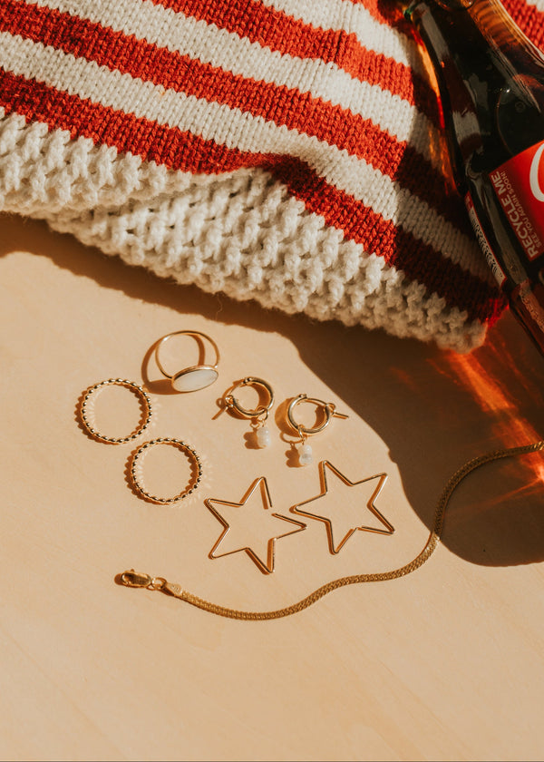 Hello Adorn Star Threader Earrings styled on a flat with other Americana props.