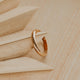 Gold ring on a wooden surface with geometric shapes