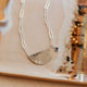 Silver necklace with a pendant on a decorative plate