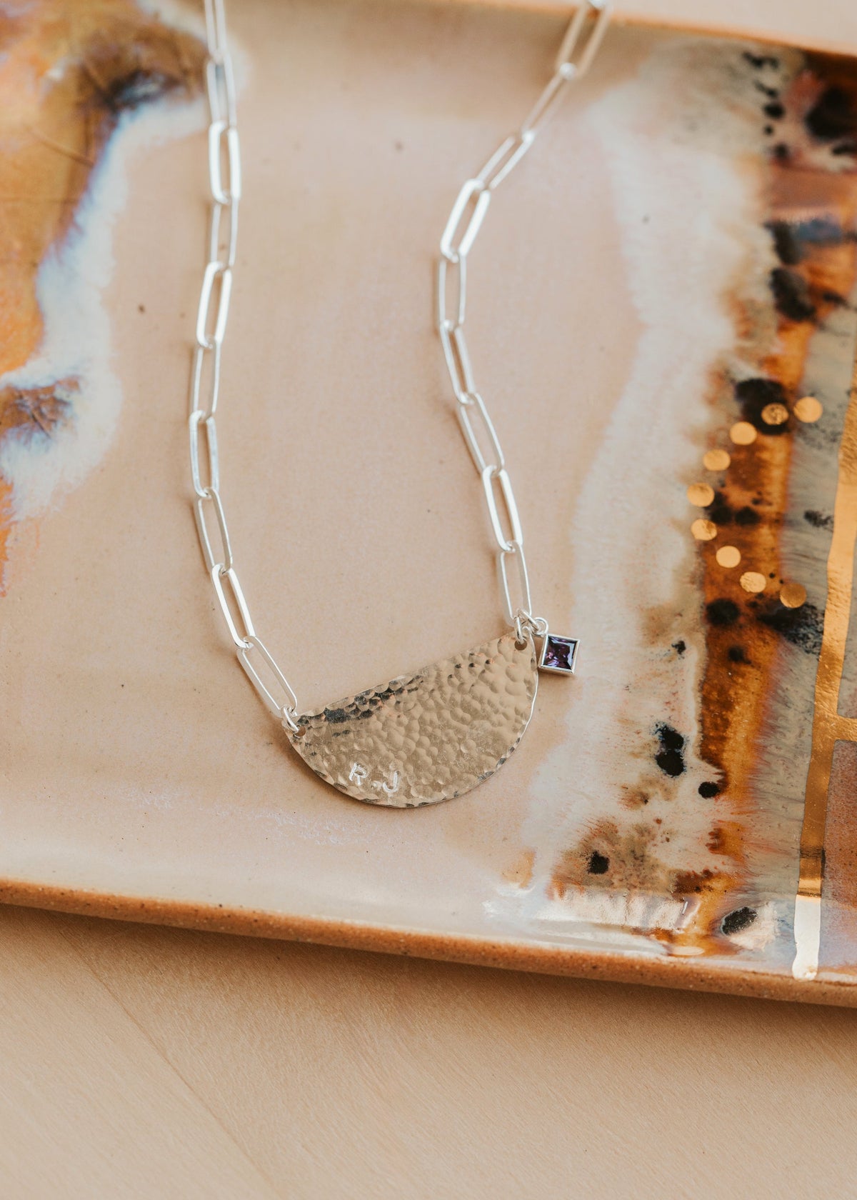 Silver necklace with a pendant on a decorative plate