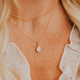 14K Gold Fill Rosalie Necklace by Hello Adorn - oval pink stone pendant on model's neckline layered with satellite chain