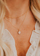 14K Gold Fill Rosalie Necklace by Hello Adorn - oval pink stone pendant on model's neckline layered with satellite chain