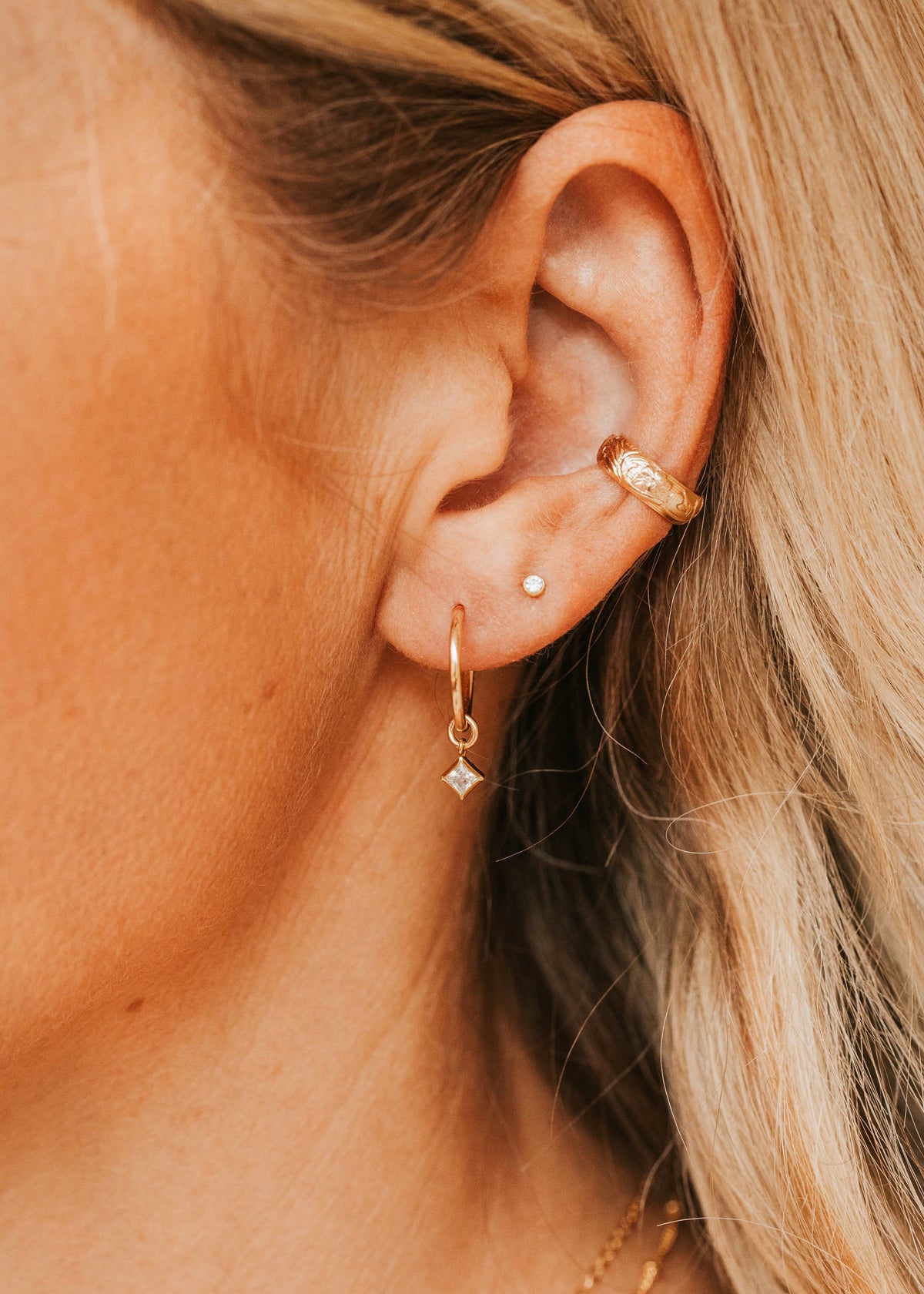 14K Gold Fill Grace Charms by Hello Adorn - CZ charm huggie worn in model's ear with layered ear stack