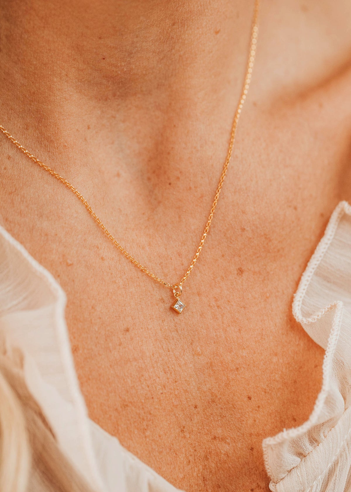 14K Gold Fill Grace Necklace by Hello Adorn - tiny CZ star pendant on delicate chain worn on model's chest