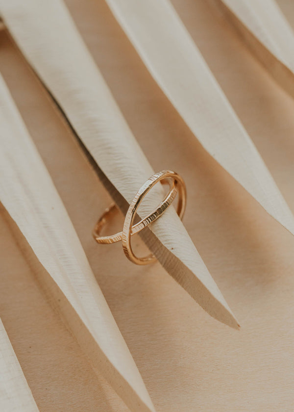 Gold ring on a textured beige surface