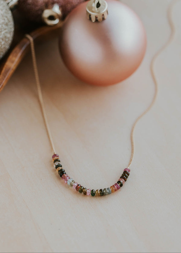 Necklace with colorful beads on a surface with Christmas ornaments