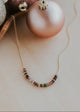 Necklace with colorful beads on a surface with Christmas ornaments