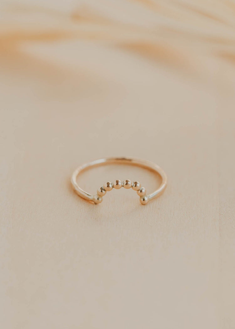 Gold ring on a beige marble surface