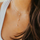 Close-up of a woman wearing a delicate necklace with small beads.