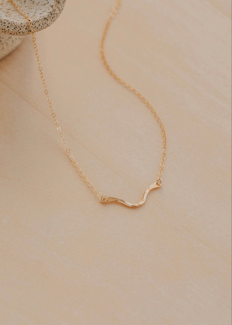 Gold necklace on a beige surface