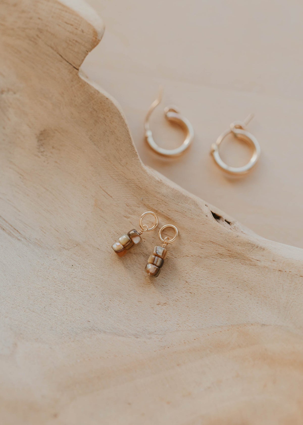 Gold hoop earrings on a wooden surface