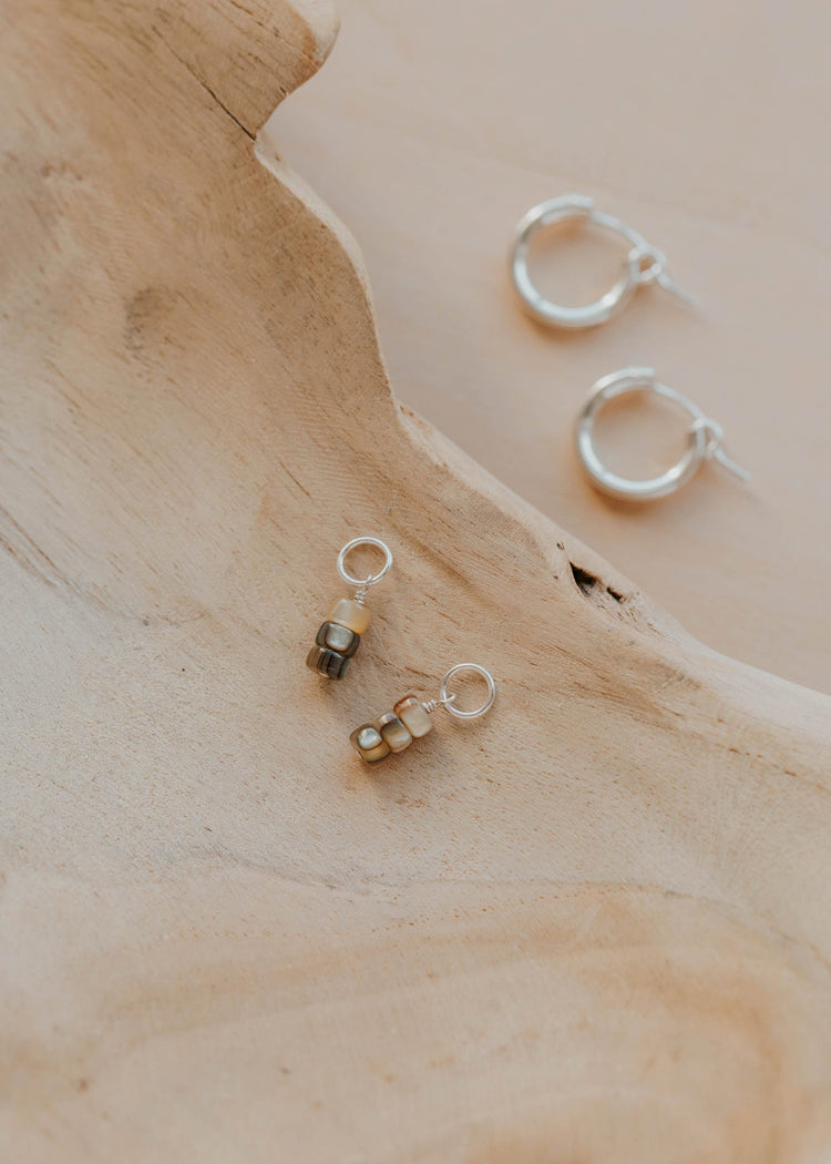 Three pairs of earrings on a wooden surface