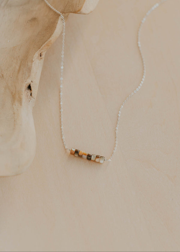 Necklace with a small pendant on a beige background