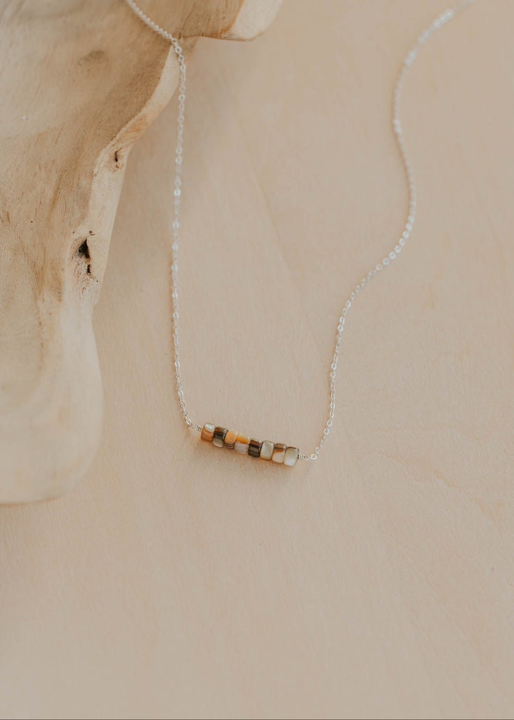 Necklace with a small pendant on a beige background