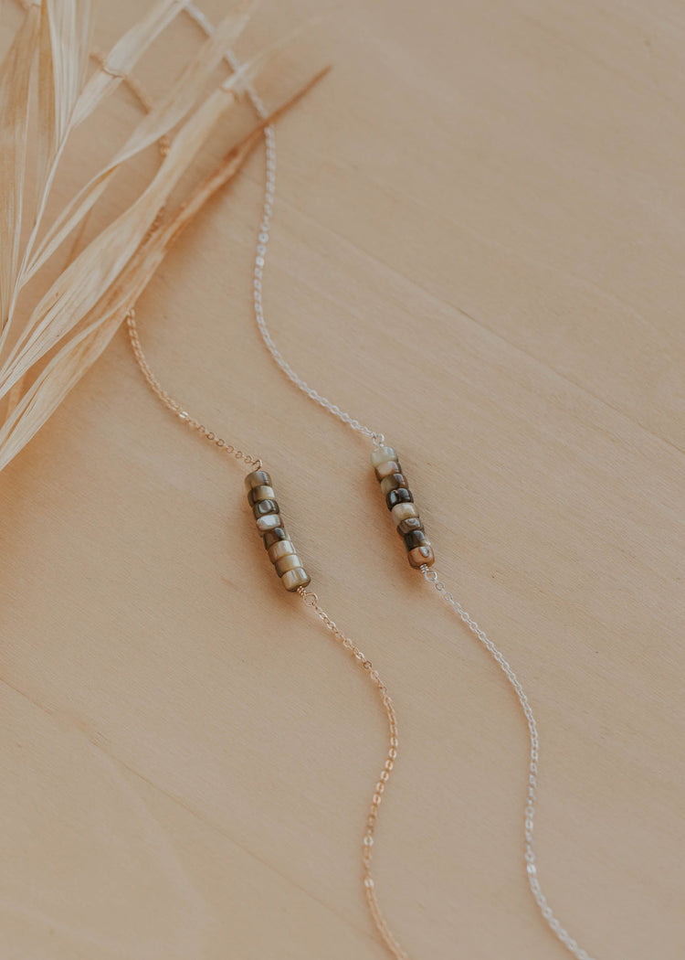 Necklace with beaded pendants on a beige background